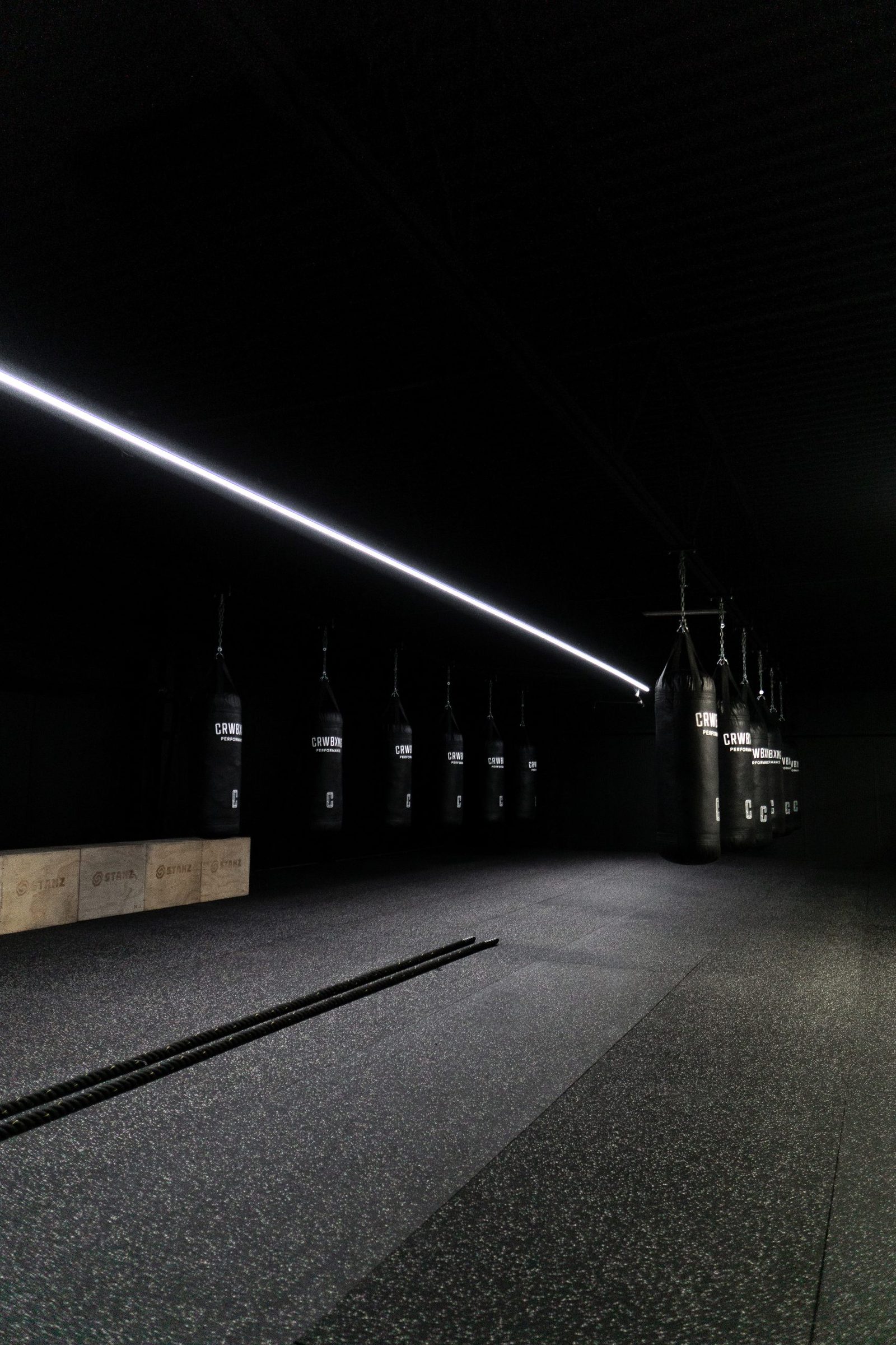 Studio de boxe sombre avec rangée de sacs de frappe
